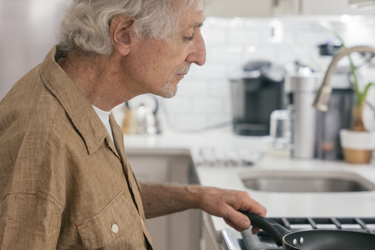 Senior man preparing breakfast in his kitchen